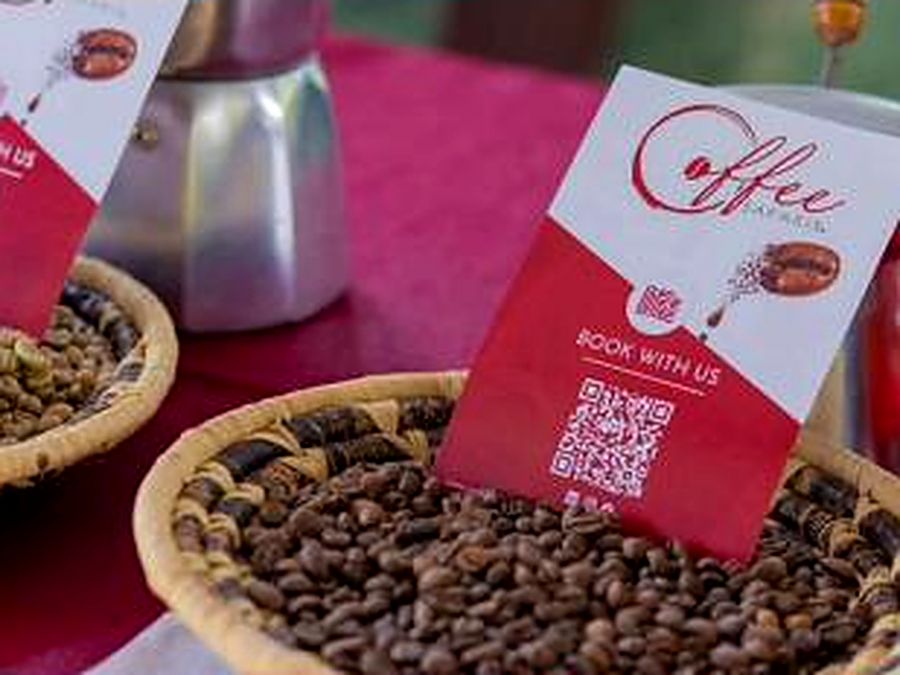 A basket of roasted beans beside the Coffee Safaris booking card.